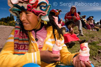 Varias mujeres del pueblo de Llachón vestidas con un trajes típicos regionales asisten como público a un partido de fútbol mientras saborean un helado. 